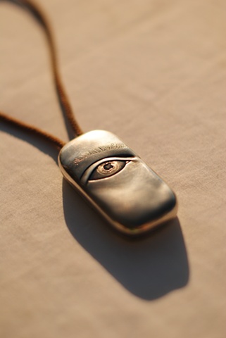 Locket with two latches and a relief carving of an eye on the face