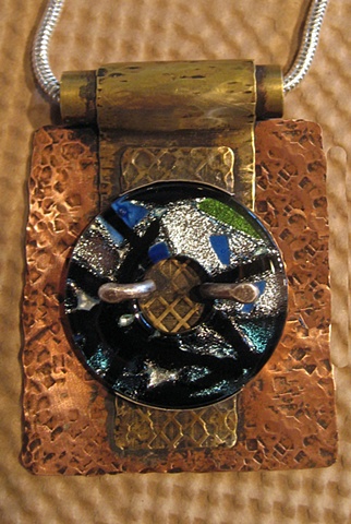 This bezel set dichroic pendant is set in copper and brass