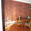 Freehand cotton plant motif with matte plaster striae overlay in dining room.