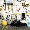 Man with blue blanket and graffitti