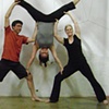 Dan and Jane in Warrior II with me in a stacked handstand 