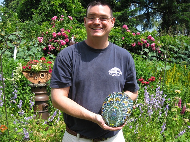 Student with finished mosaic garden art 