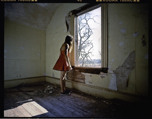 Jess looking out the window in a stunning red dress