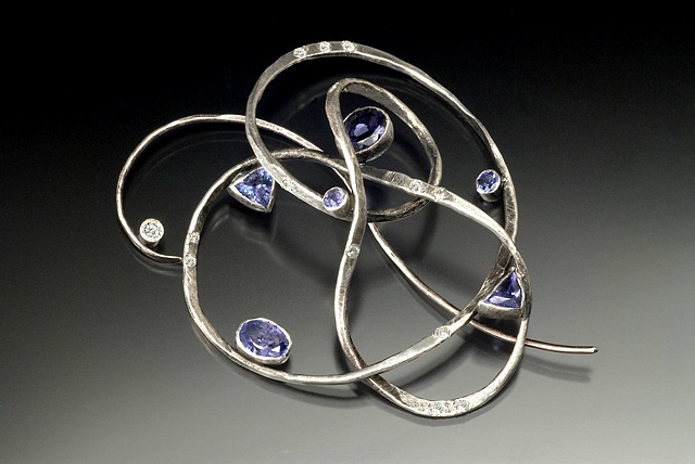 This brooch/pendant was forged and fabricated. Each bezel was individually created for each stone.