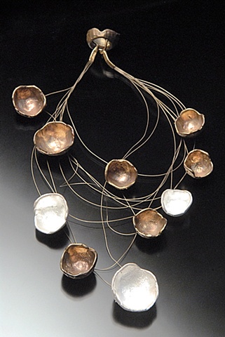 Each piece was individually crafted in wax and then fabricated to hang in a balanced orbit around the neck.