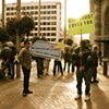 Photograph from performance standing with Jesus Christ Loves You sign guy.