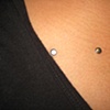 close up shot of two of four healed dermal anchors on the chest