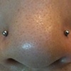 Two fresh nostril piercings with plain surgical steel stud.  