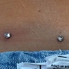 Three very healed dermal anchors on the lower back.  Freshly changed the left and right tops from disc back to Cz.  A little red from being changed, to be expected.