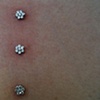 Very healed dermal anchors on the chest.  Freshly changed to the Industrial strength flower CZ's.