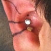 Two fresh conch piercings with Labret studs, one to go.