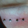 Two fresh surface piercings underneath collar bone on the right side.