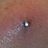 Fresh 18 gauge anchor on the cheek with a bezel set CZ.