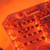 Glowing shelf of beads about to be pulled out of the kiln