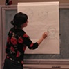 Rene demonstrating how to draw a character from the book Papi's Gift