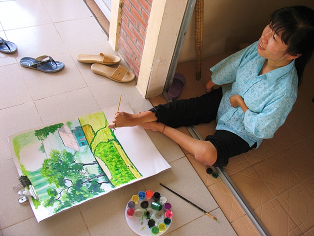 Sum, a residant of a training facility outside of Ho Chi Minh City specifically designed for persons effected by Dioxin, is an artist that paints with her feet.