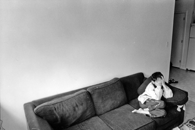 Faysel's son sits shyly on the couch the day before the big move to Portland from Lewiston, Maine.