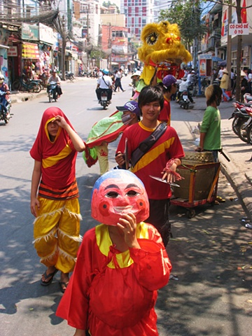 Children perform the "Kitchen Dance" in random homes in Saigon, banging the drum and scaring away the spirits for the coming year.