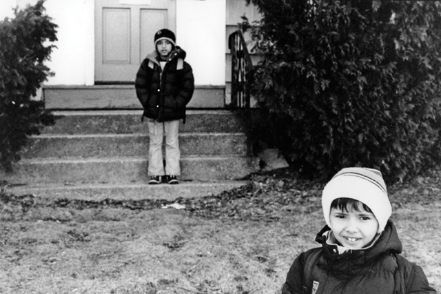 Faysel's sons wait for the bus outside of their house in Portland, Maine.