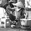A woman prepares Pho on the street in downtown Saigon.