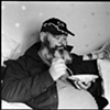 Bill eats cereal in his living room in Freeport, Maine, with his 25 year old iguana, Mogwana.