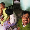 A mother sits with her three developmentally disabled children in their home outside of Danang.