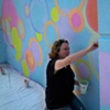 Artist Ani Hoover painting outside facade of 
Starlight Studio Gallery