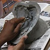 Donald Brown hollowing a clay sculpture.