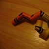 a yellow-orange crayola crayon molting into dandelion