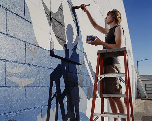 Thane Lund, Painting a mural he designed on the Crosby Sports Arena, Crosby, ND  2003