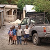 Children standing by a pickup truck
L&eacute;og&acirc;ne