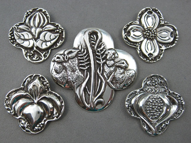 sterling silver quatrefoil shape pendants with symbolic elements by Nancy Denmark