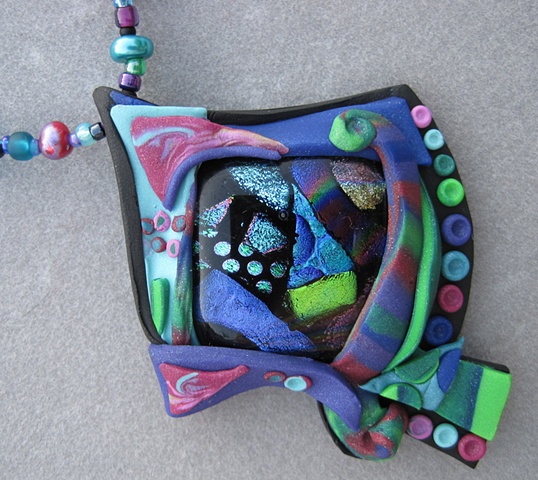 polymer clay pendant built around fused glass focal
