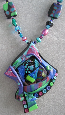 polymer clay pendant featuring fused glass focal