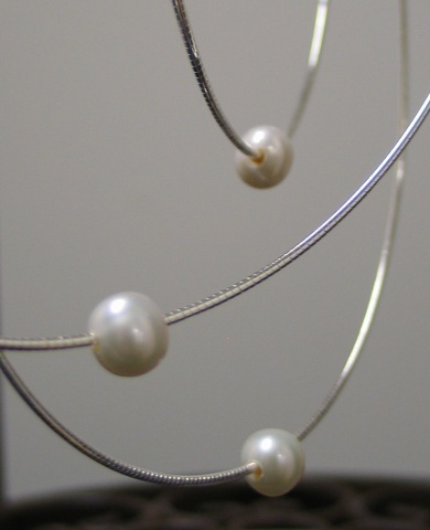 CLOSE UP OF DRILLED PEARL ON CHAIN