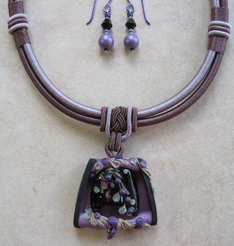 polymer clay pendant with lampwork bead feature on cord