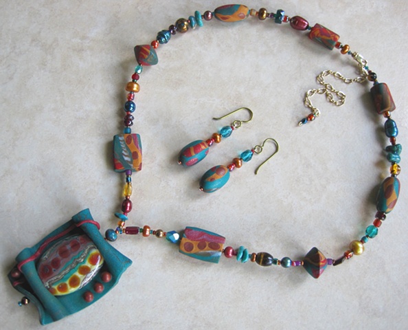 beaded necklace featuring polymer clay pendant with lampwork bead focal