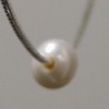 CLOSE UP OF DRILLED PEARL ON CHAIN