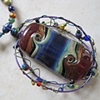 WIRE WRAP CAGE PENDANT
FEATURING LAMPWORK BEAD ON
POLYMER CLAY BEADED NECKLACE SET
CLOSE UP VIEW