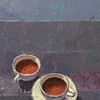 Two white cups on blue/gray