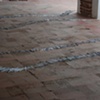 Exhibition Flying Carpet Prayers at El P&oacute;sito, on the floor, rolled newspaper from Catalunya in the shape of Ca&ntilde;adas Real