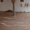 Exhibition Flying Carpet Prayers at El P&oacute;sito, performance workshop props, cardus plant, and on the floor, rolled newspaper from Catalunya in the shape of Ca&ntilde;adas Real